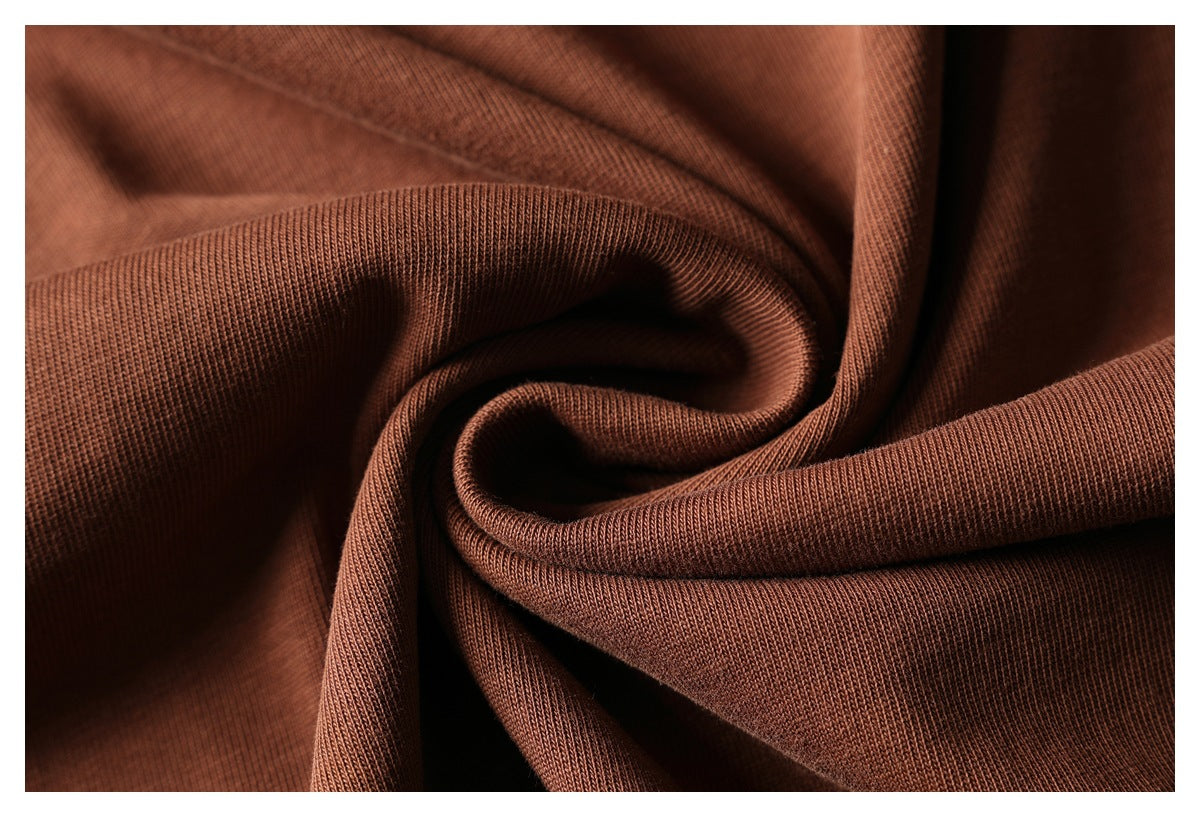 Close-up of rust-brown fabric gathered to show its fine ribbed texture.