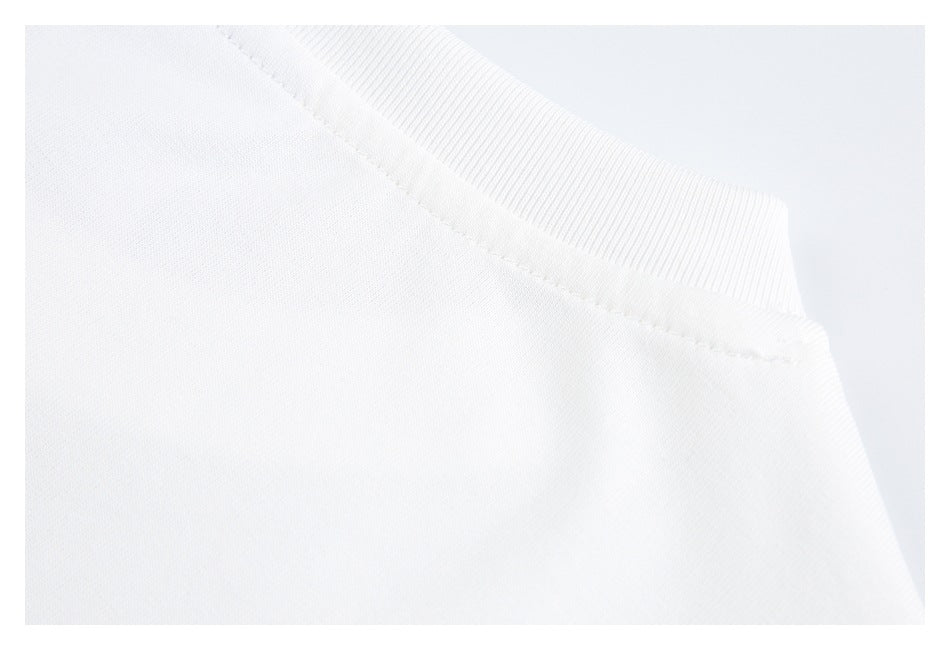 Close-up of the ribbed neckline and shoulder stitching on a white garment.
