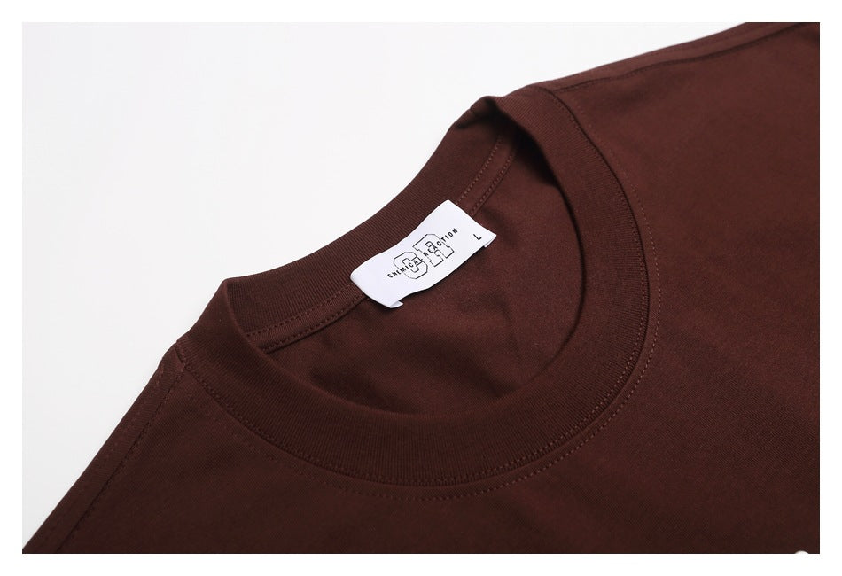 Close-up of a dark brown T-shirt's crew neckline, stitching, and neck label.
