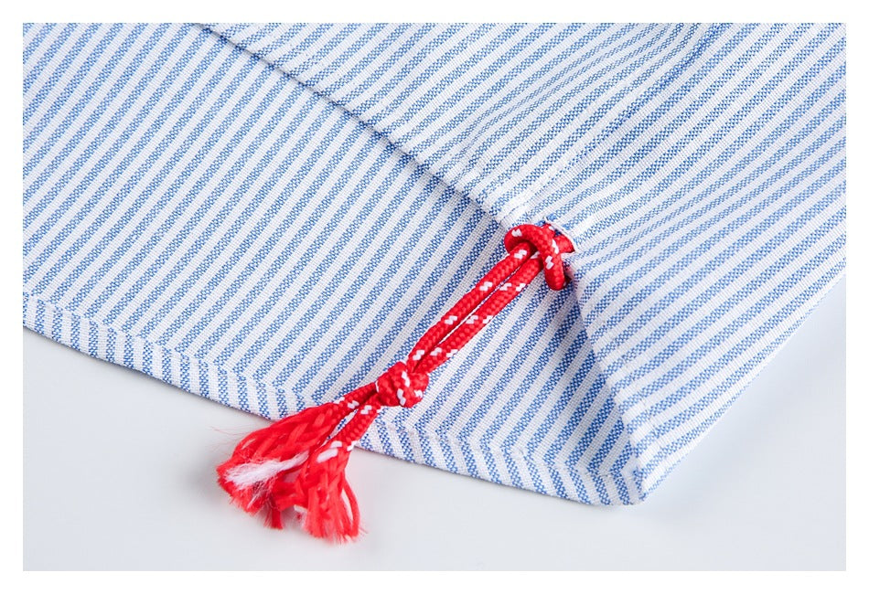 Blue-and-white striped garment detail with a bright red braided cord and tassel.