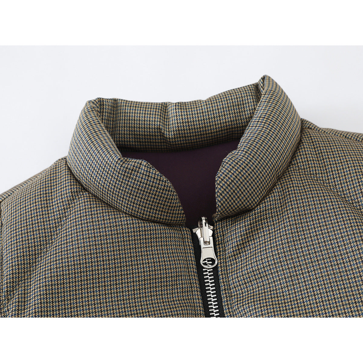 Close-up of a small tan, blue, and dark check pattern, raised collar, plum lining, and front zipper on a vest.