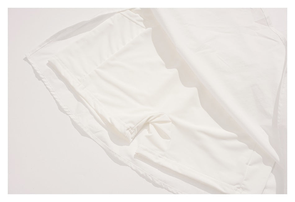 Close-up of the inside of a white garment, showing stitched seams and a folded edge.