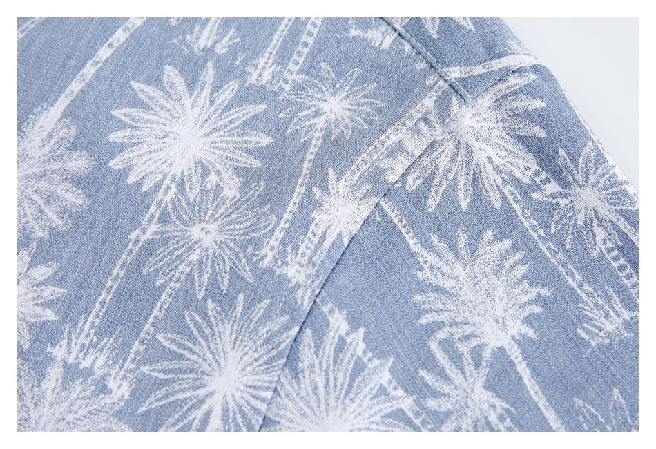 Close-up of the light blue and white palm-tree print fabric and a curved garment seam.