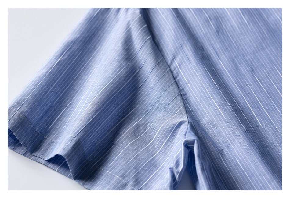 Close-up of the blue pinstriped shirt's short sleeve, side seam, and stitching.
