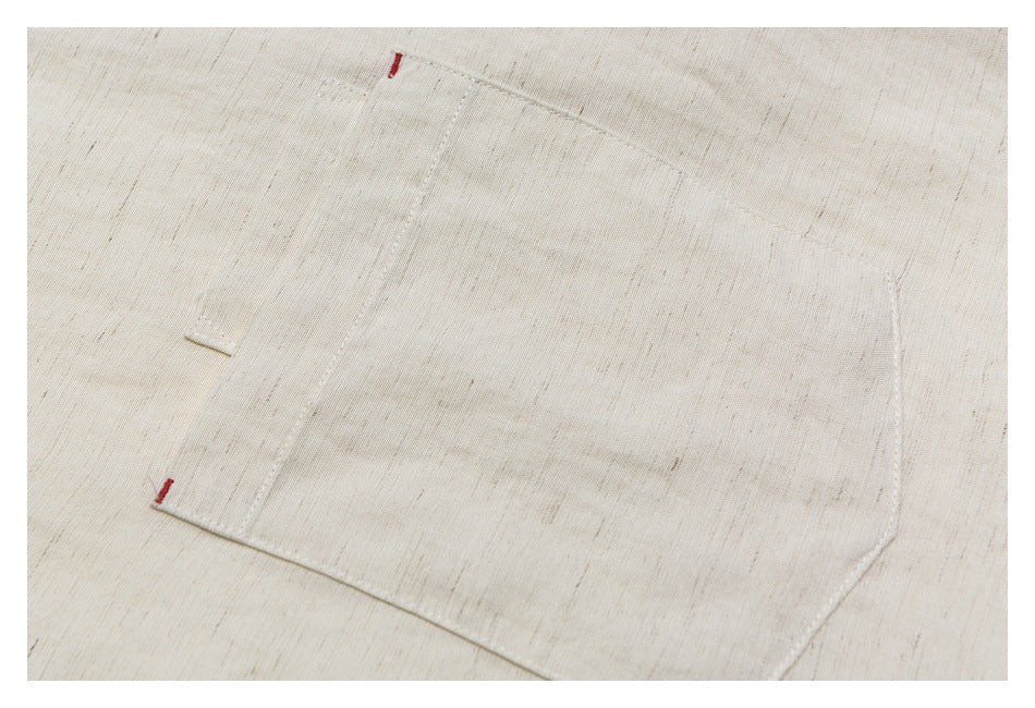 Close-up of a rectangular chest pocket with small red bar tacks on the off-white shirt.