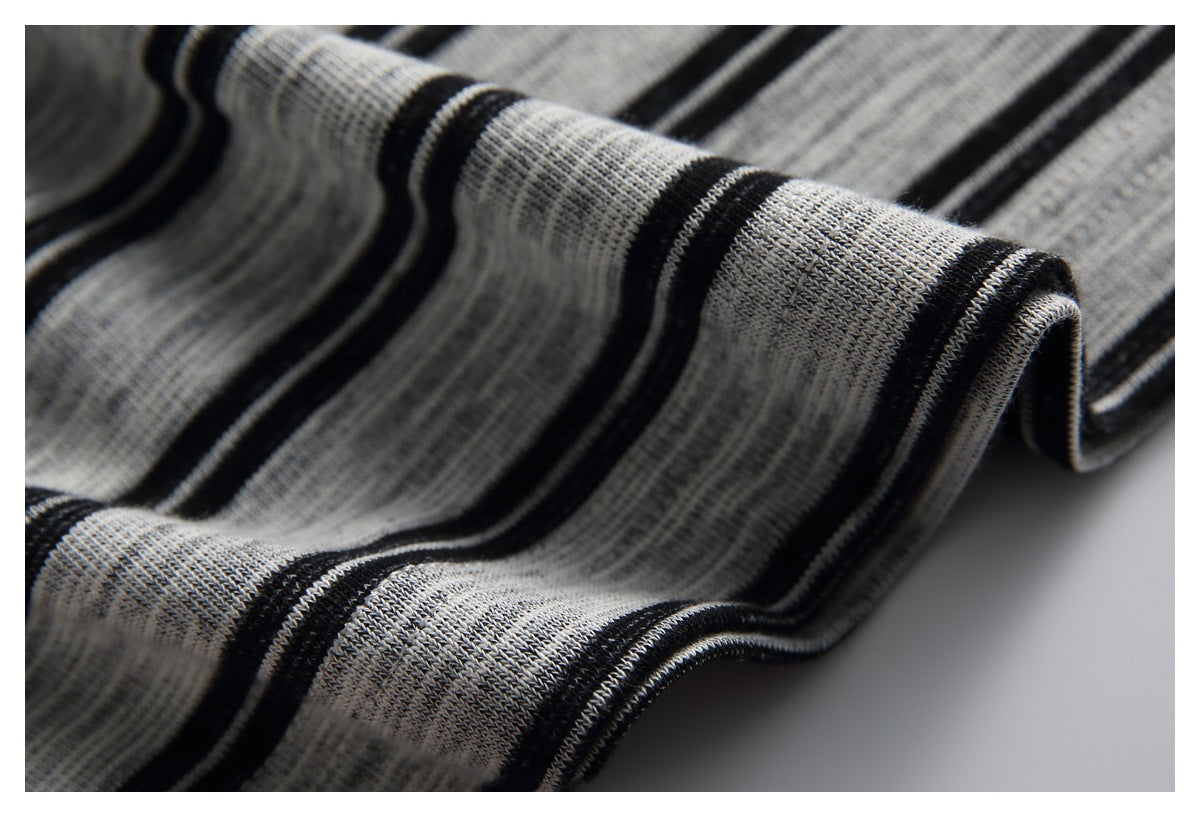 Close-up of gray and black striped knit fabric folded to show its ribbed texture.