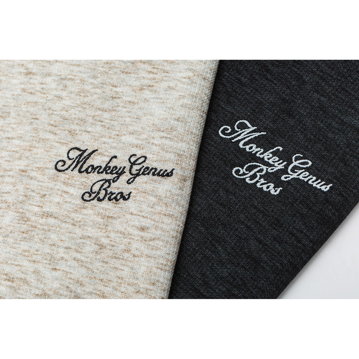 Close-up of black script embroidery on light beige and charcoal heather fabric.