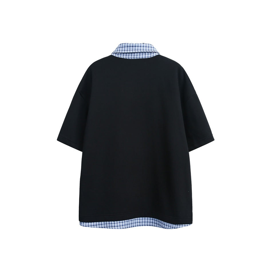 Back view of a black short-sleeve top with a blue plaid collar and matching plaid hem trim.