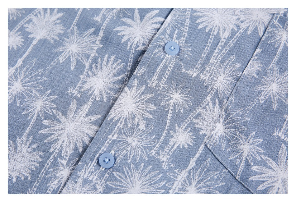 Close-up of the blue shirt’s button placket, blue buttons and white palm-tree print.