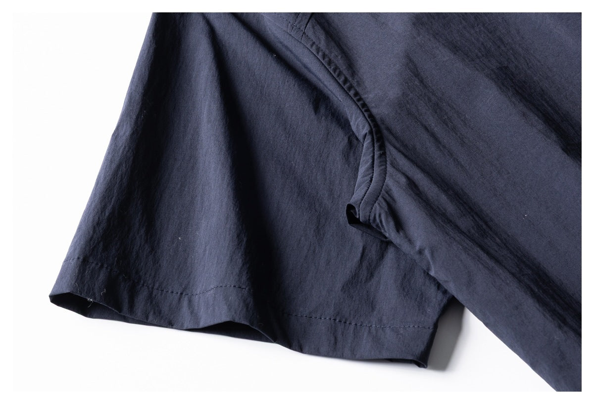 Close-up of a dark navy garment sleeve and seam against a white background.