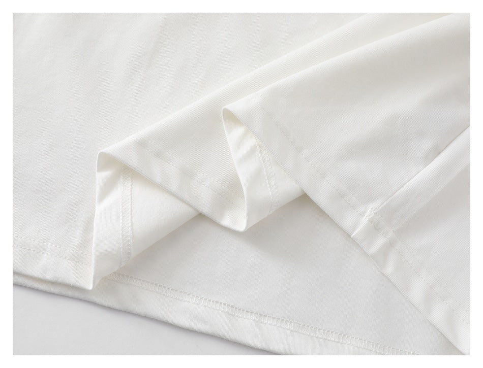 Close-up of the white T-shirt's folded hem and visible stitching.