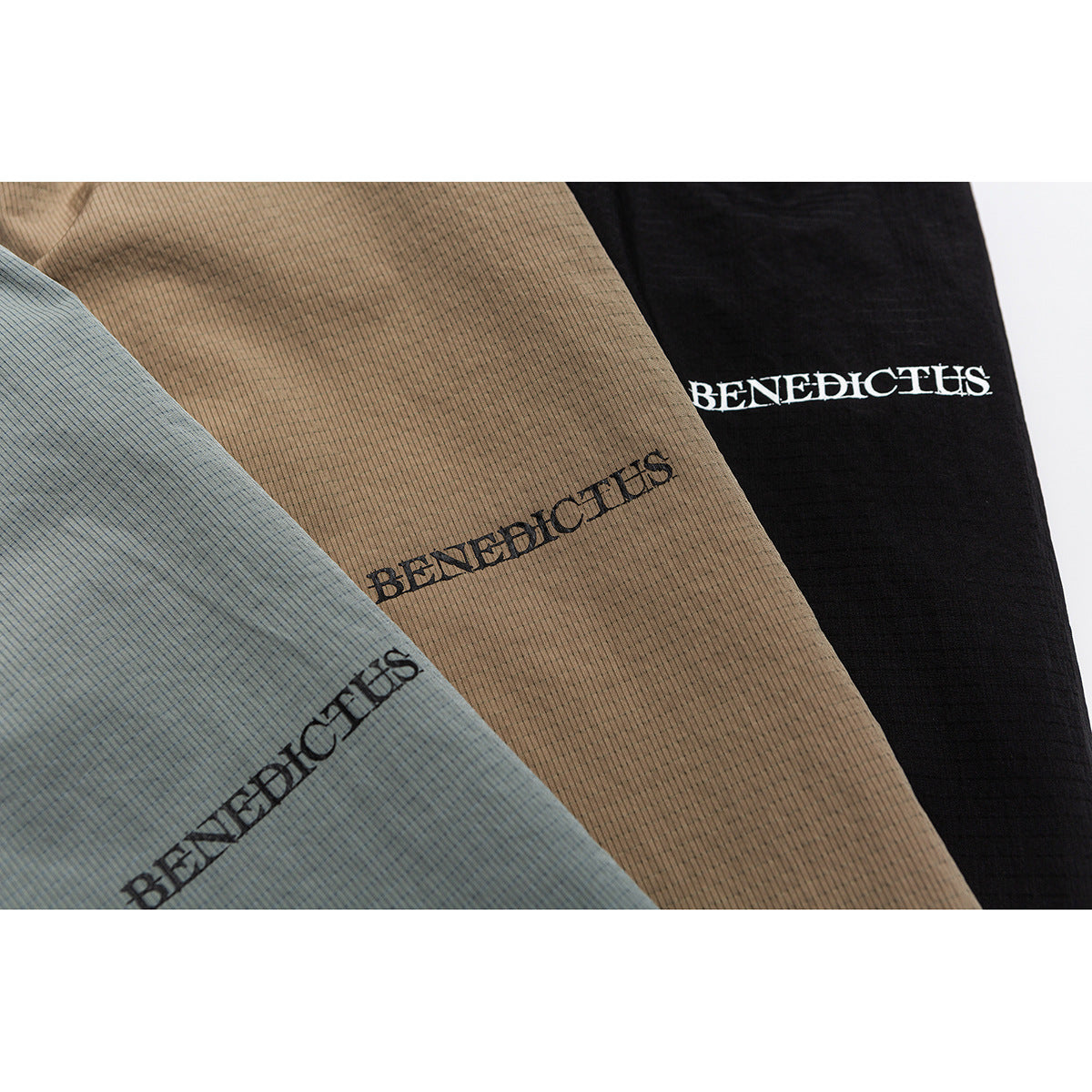 Close-up of gray-blue, tan, and black fabric panels, each with BENEDICTUS lettering.
