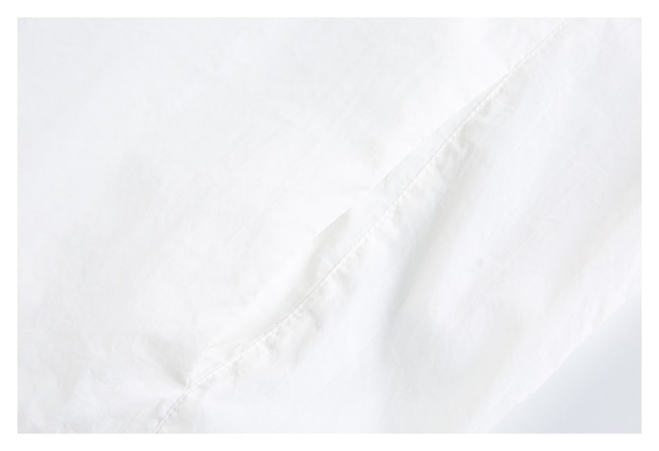 Close-up of a diagonal stitched seam on white jacket fabric.