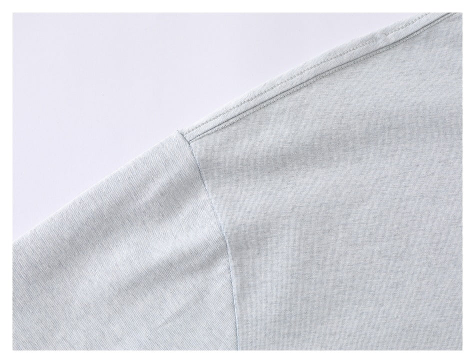Close-up of the light gray T-shirt's shoulder seam and sleeve construction.