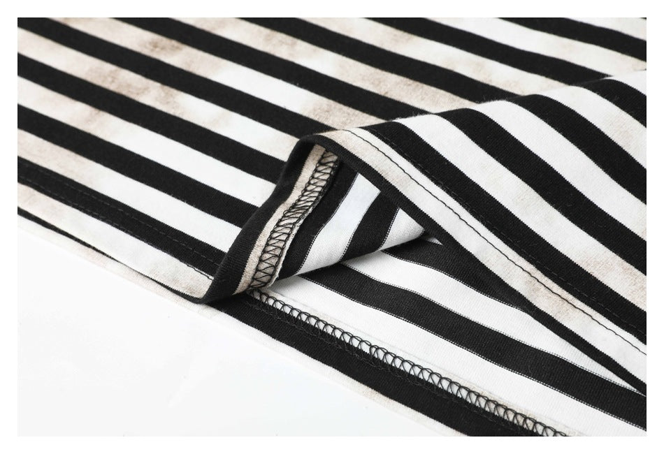 Close-up of the black-and-white striped garment hem, showing its folded edge and overlock stitching.