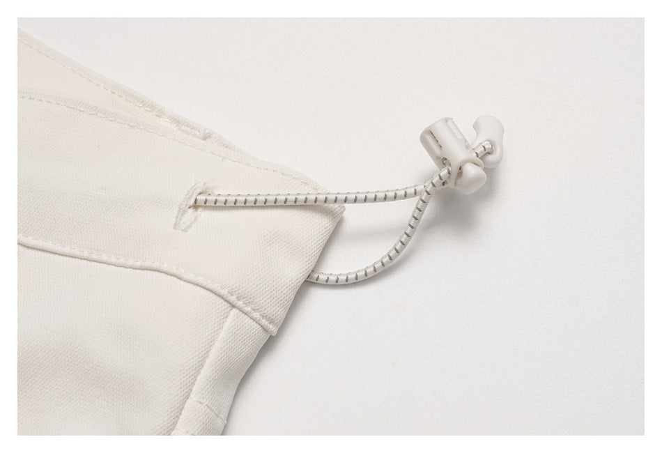 Close-up of a striped adjustable drawcord and toggle at the pants waistband.