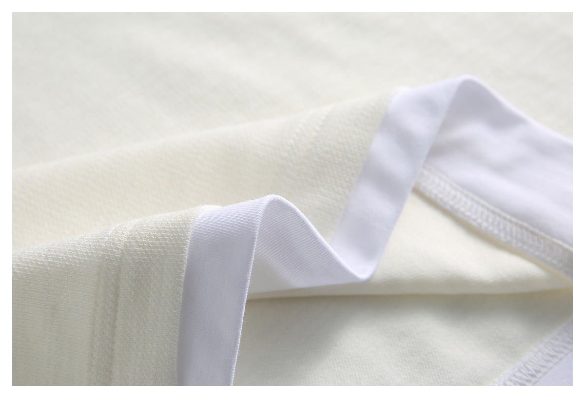 Close-up of an ivory knit garment seam with white inner binding exposed along the edge.