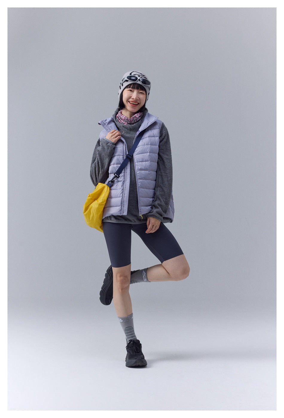 Model wearing a pale lavender quilted puffer vest over a gray fleece, shown from the front.