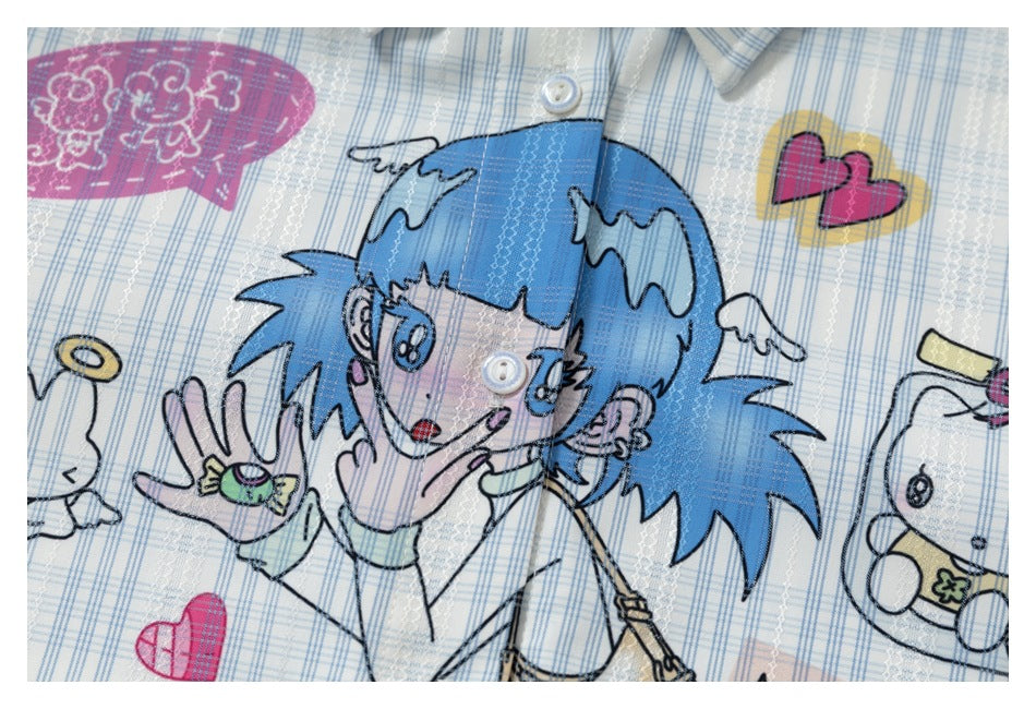 Close-up of a white and blue plaid shirt with a large colorful cartoon girl print and white buttons.