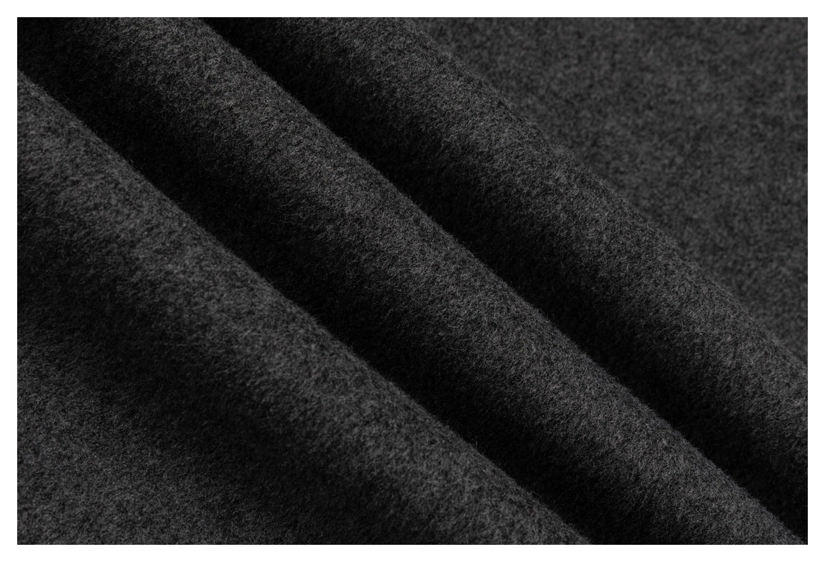 Macro view of the fuzzy surface texture of dark charcoal fabric.