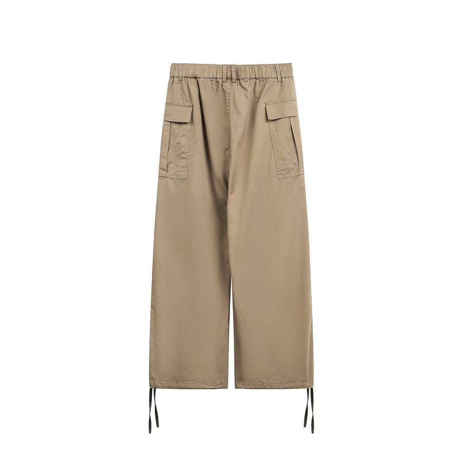 Back view of khaki wide-leg cargo pants flat lay with elastic waistband, side flap pockets and hem drawcords