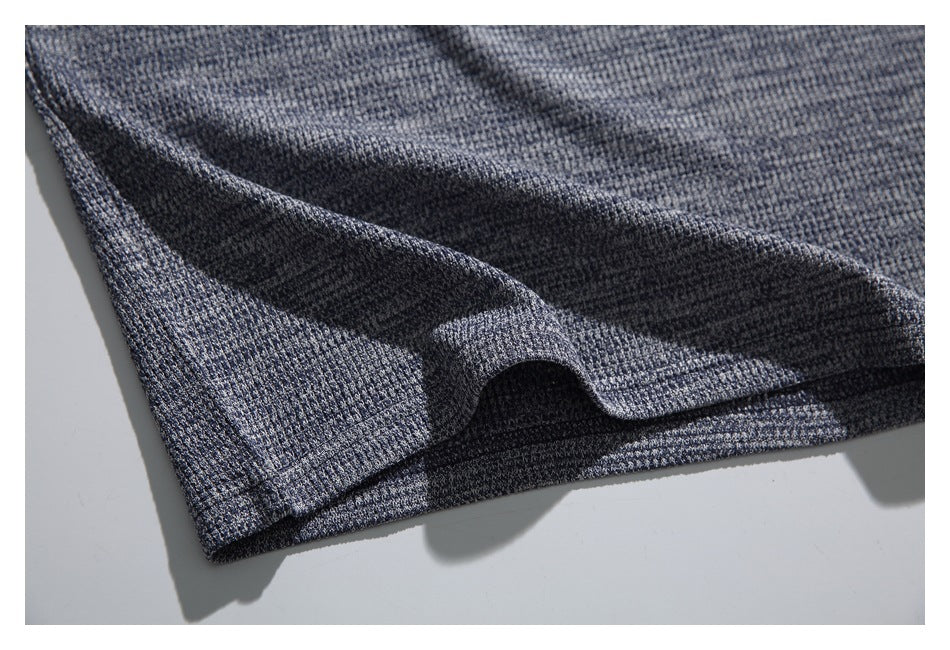 Close-up of the gray-blue textured top's lower hem and fabric drape.