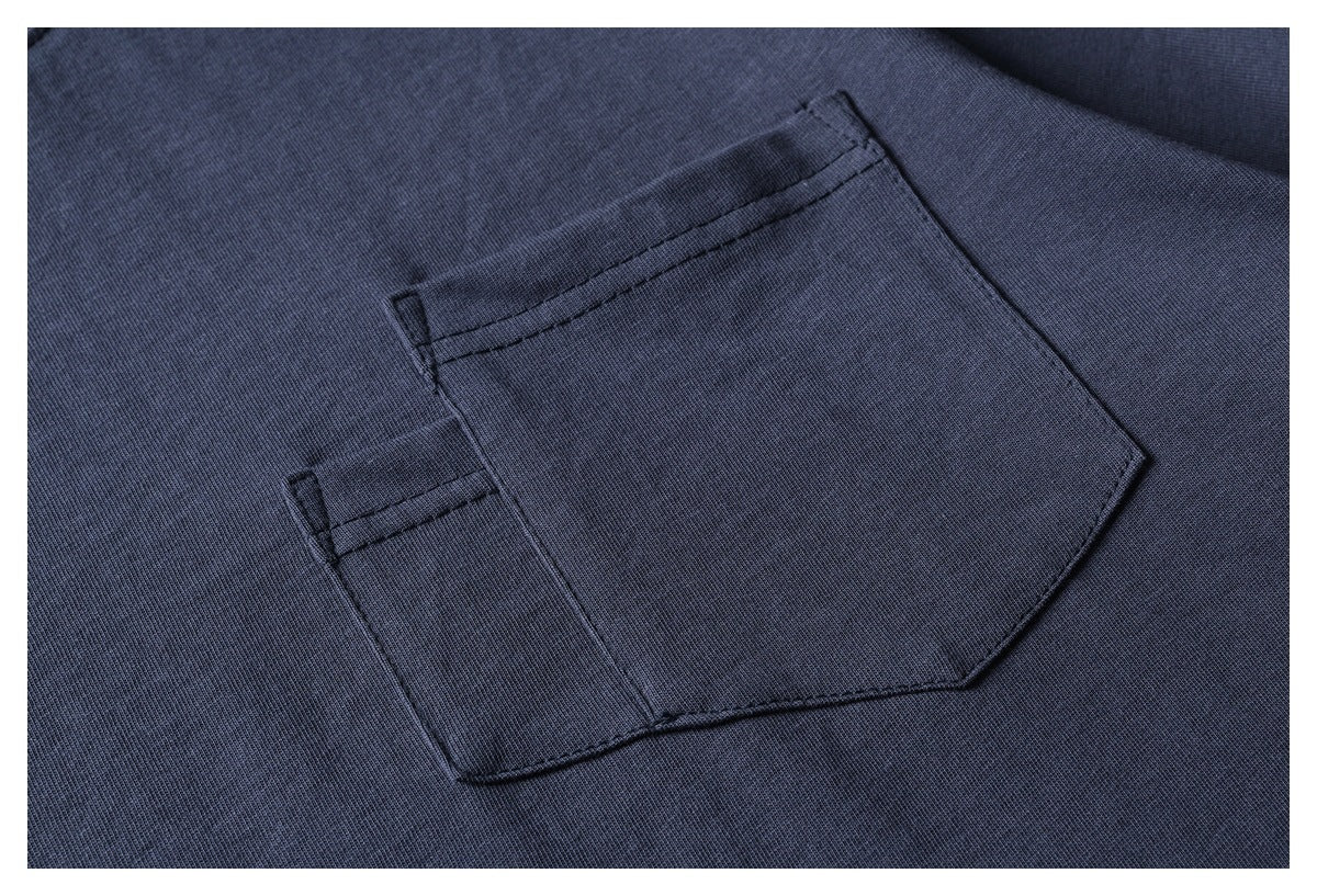 Close-up of a dark navy garment's stitched patch pocket and fabric texture.