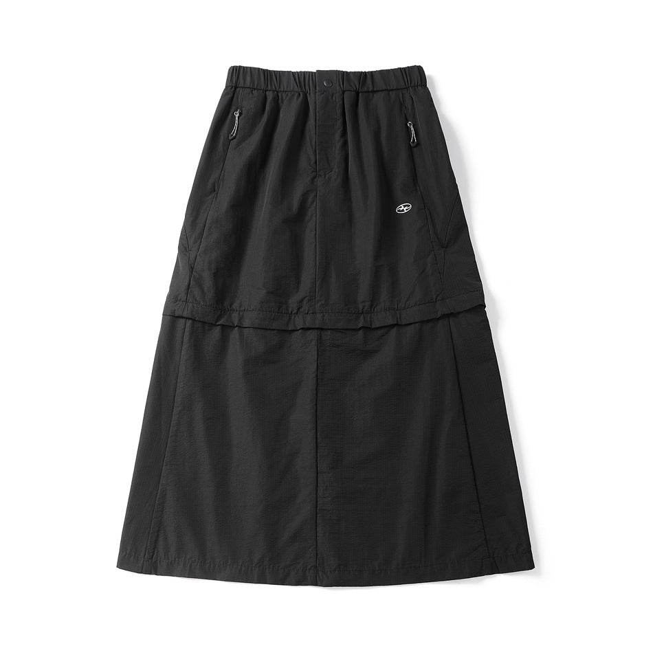 Black midi skirt flat lay with elastic waist, snap button, zip pockets with cord pulls and a two-tier seam