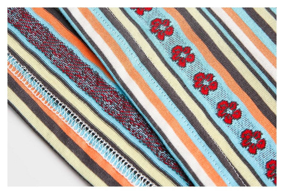Close-up of striped floral knit fabric showing the inside seam and overlock stitching.