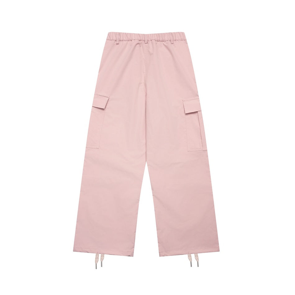Back view of pale pink wide-leg cargo pants with an elasticated waistband, flap pockets, and drawstring hems.