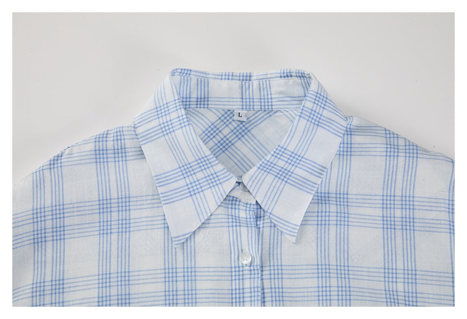 Partial front view of a white shirt with a light blue plaid pattern, pointed collar, buttons, and an L size tag.