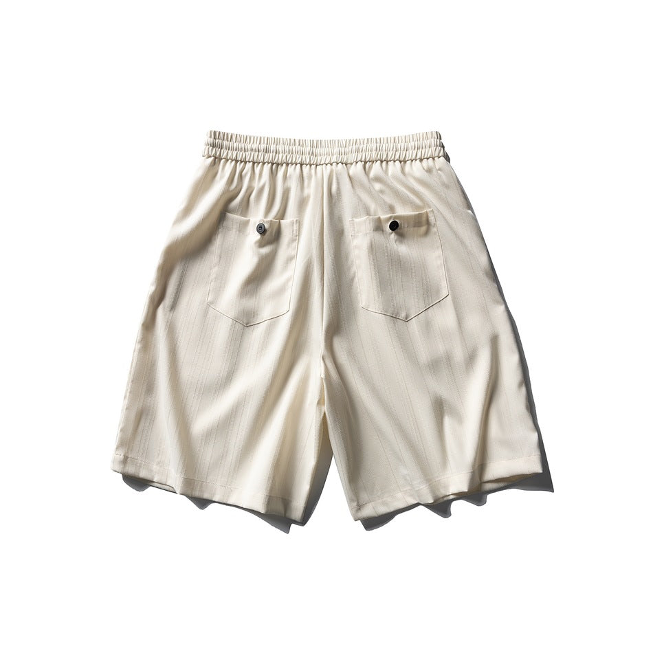 Back view of cream striped shorts with an elastic waistband and two buttoned pockets.