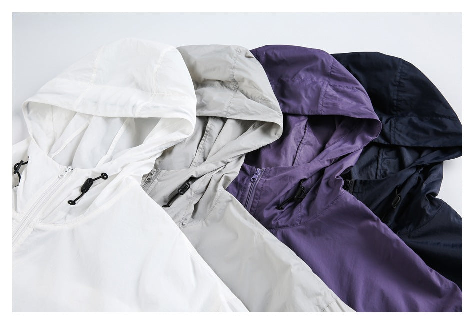 Four hooded jackets arranged together in white, light gray, purple, and dark navy, showing their front zippers and cords.