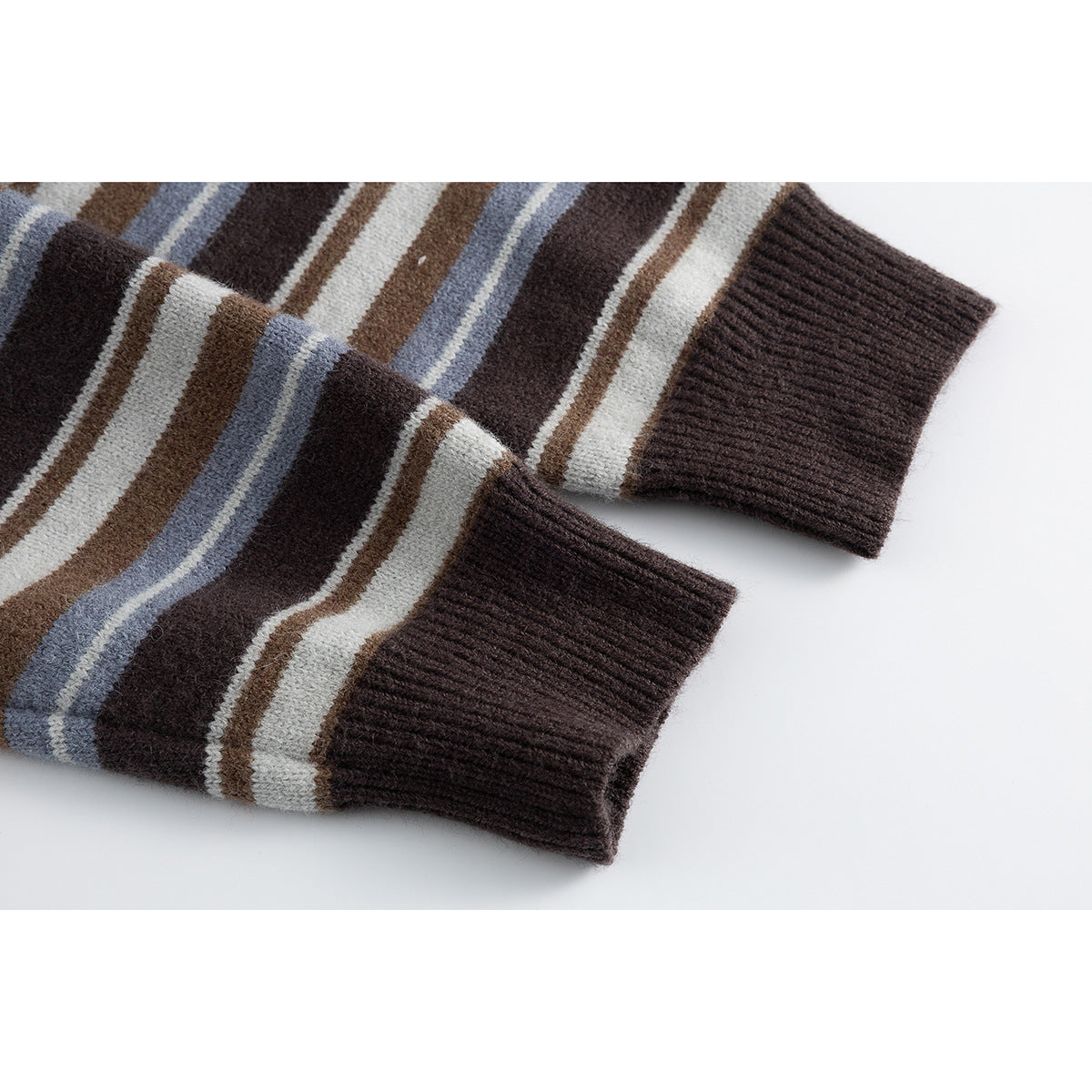 Close-up of two brown striped cardigan sleeves with dark ribbed cuffs.