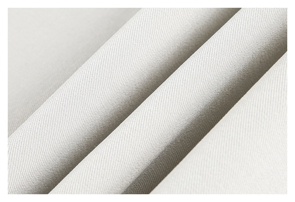Macro view of the light ivory garment's fine diagonal fabric weave and folds.
