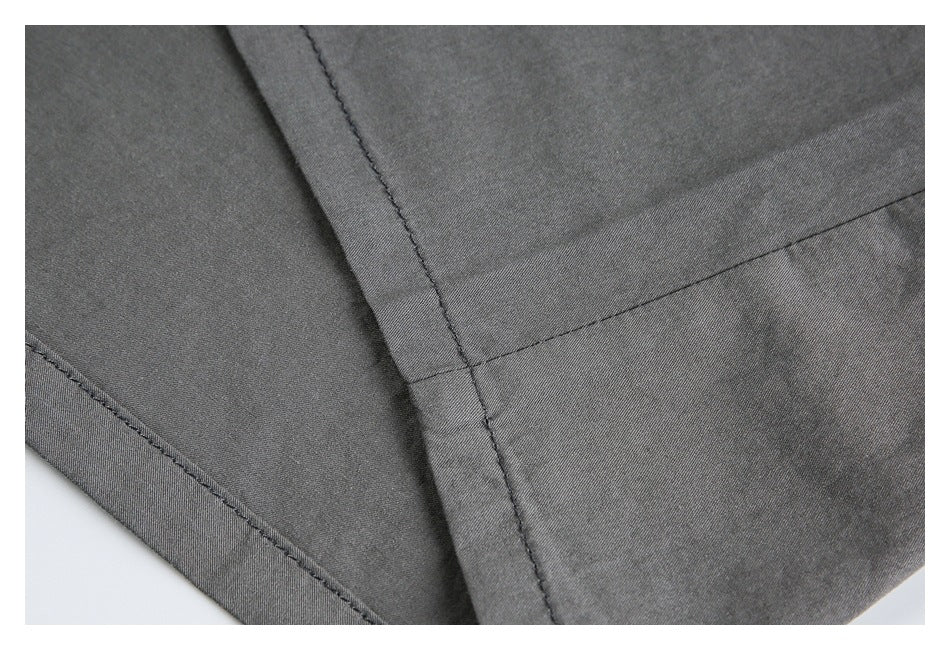 Close-up of dark gray garment fabric with intersecting stitched seams.