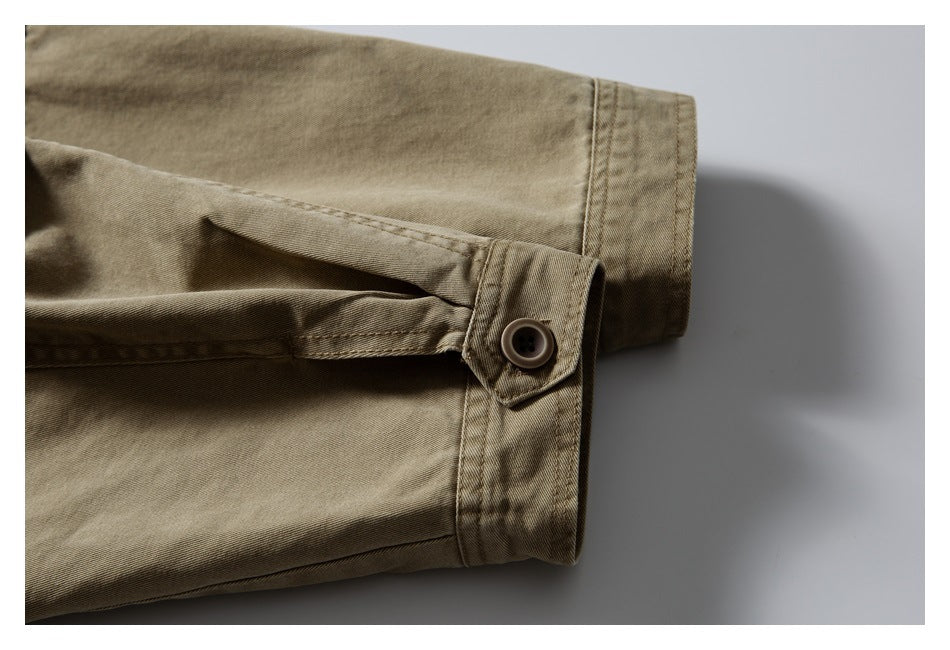 Close-up of a buttoned tab and cuff on a khaki garment sleeve.