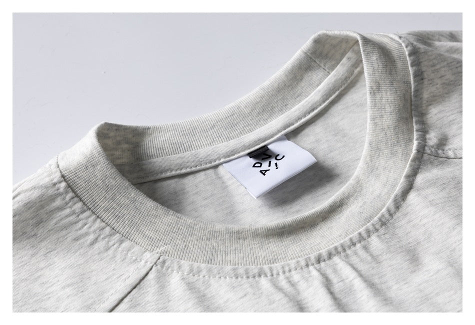 Close-up of the ribbed crew neckline and sewn-in label on a light gray marl shirt.