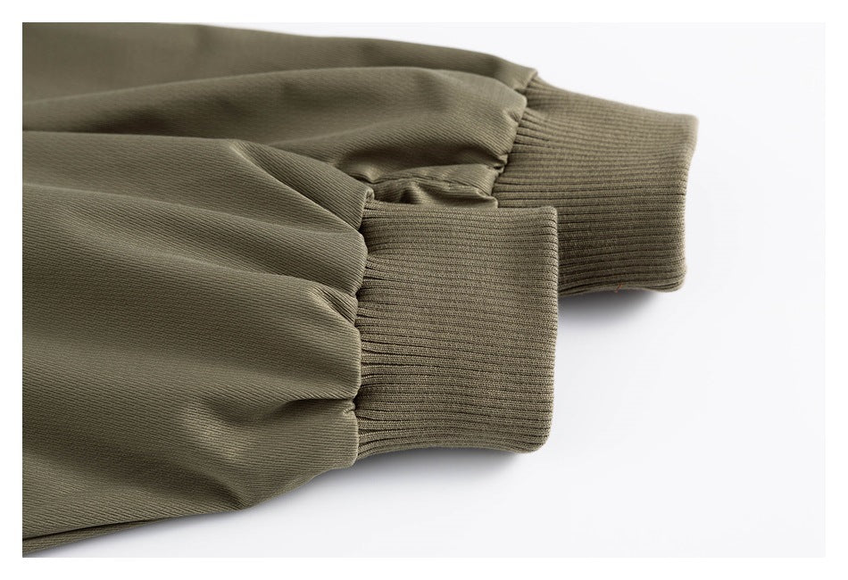 Close-up of an olive jacket sleeve gathered into a wide ribbed cuff.
