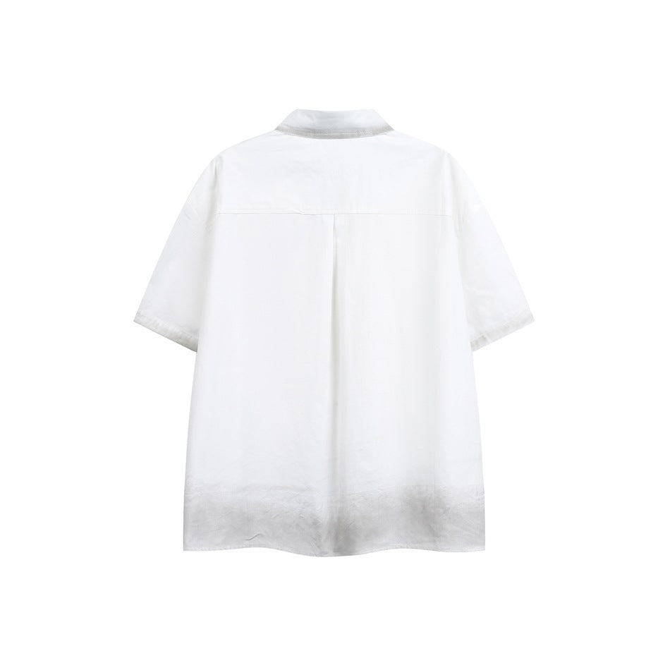 Back view of a white short-sleeve button-up shirt with a shoulder yoke and center pleat.