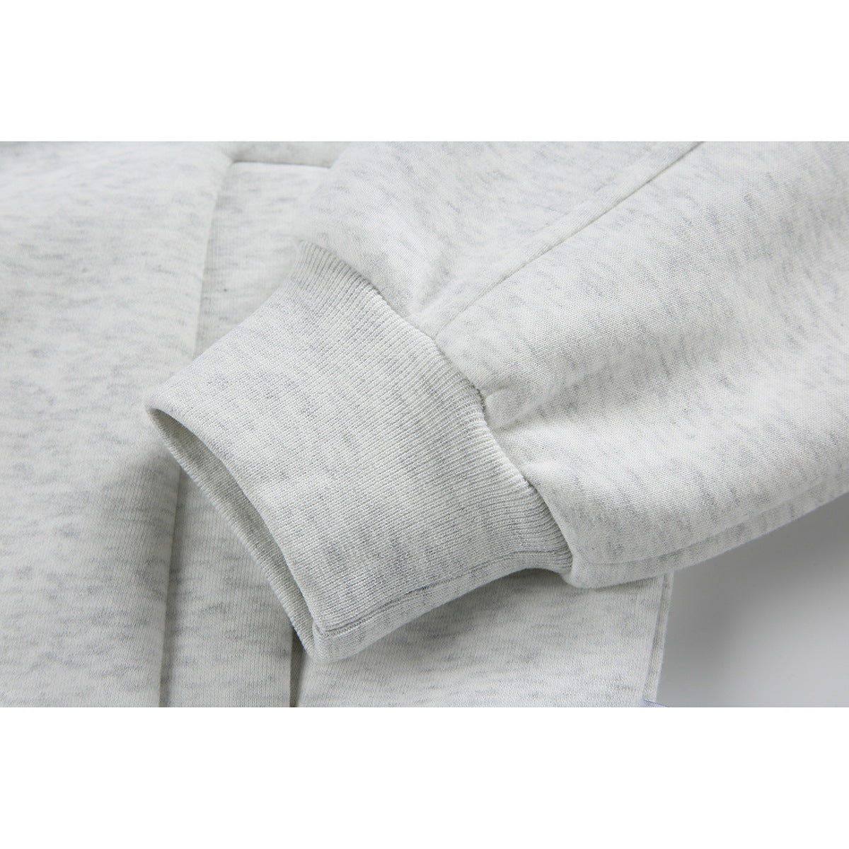 Close-up of a light gray sweatshirt sleeve and wide ribbed cuff.