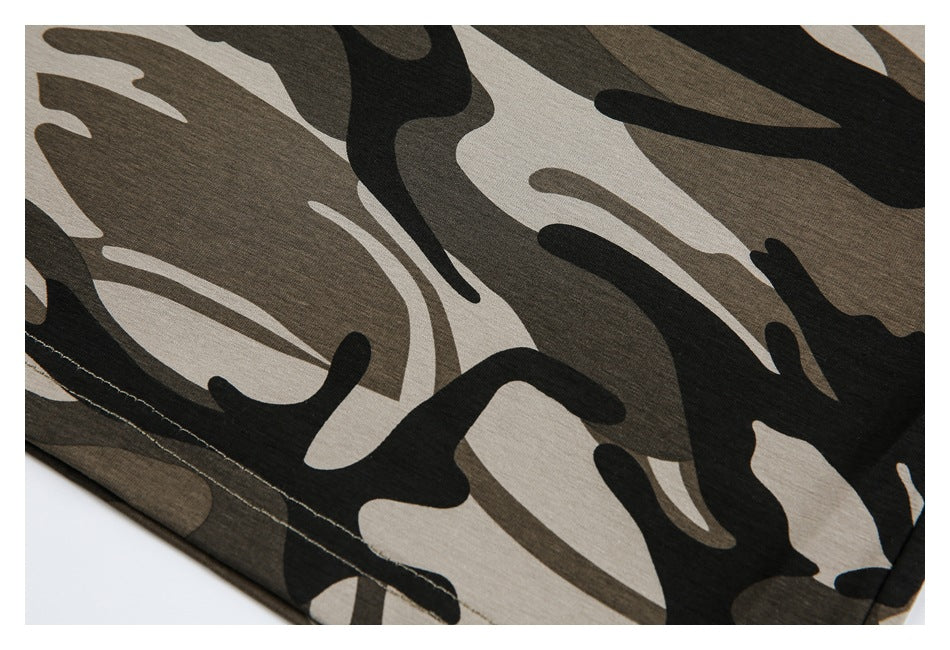 Close-up of camouflage fabric with a stitched hem along the lower edge.