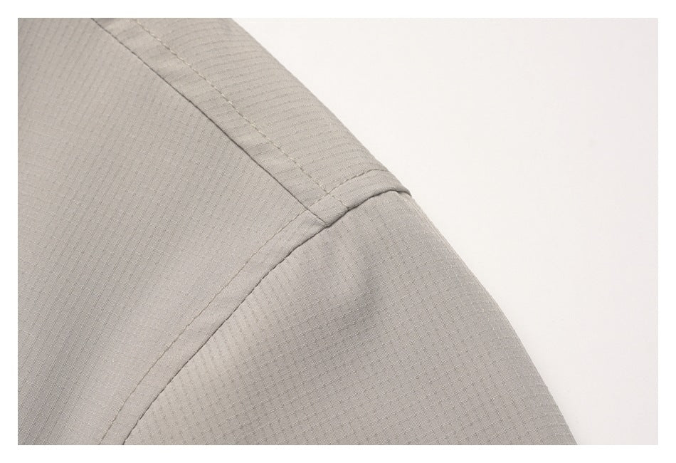 Close-up of curved shoulder and panel seams on light taupe fabric with a fine grid texture.