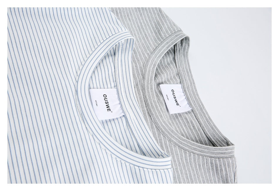 Close-up of striped T-shirt necklines and sewn labels on white-and-blue and gray-and-white versions.