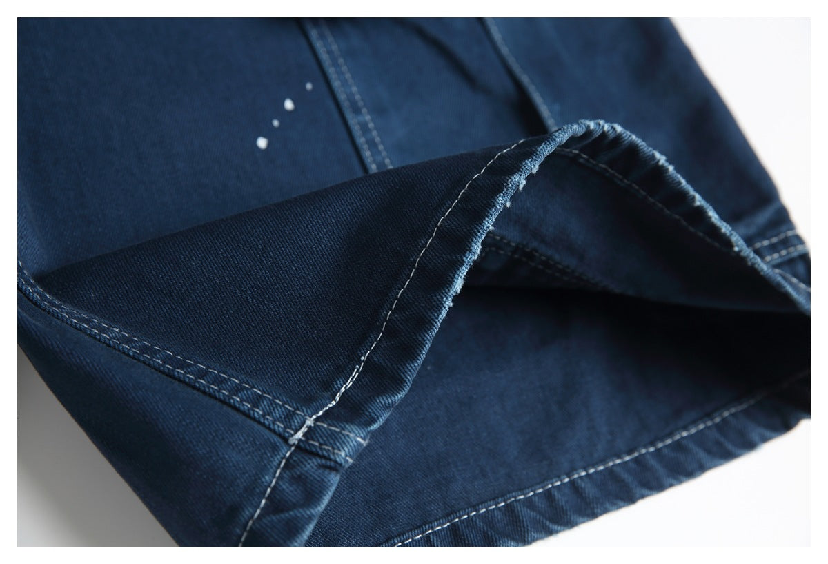 Close-up of the folded hem and inner side of dark blue jeans, showing contrasting stitching.