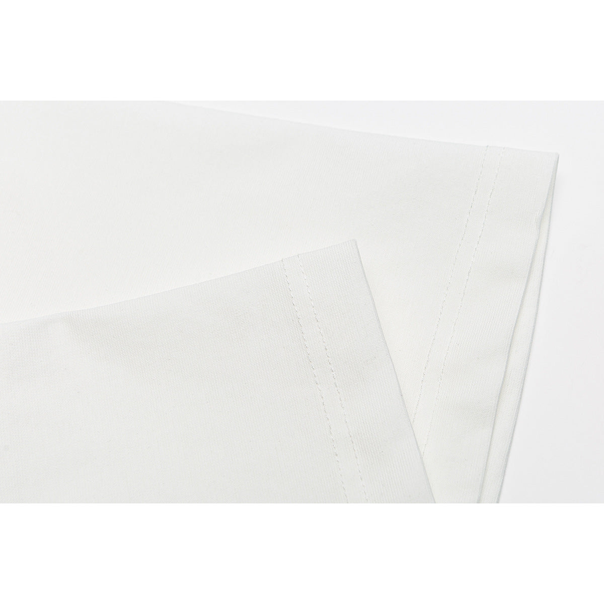 Close-up of white T-shirt sleeve hems and double-stitched seams.