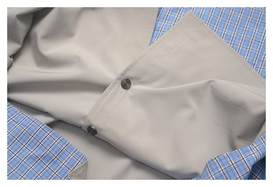 Interior view of the garment showing light gray lining, dark buttons, and blue plaid outer fabric.