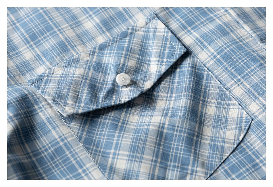 Close-up of a blue-and-white plaid shirt pocket with a buttoned flap.