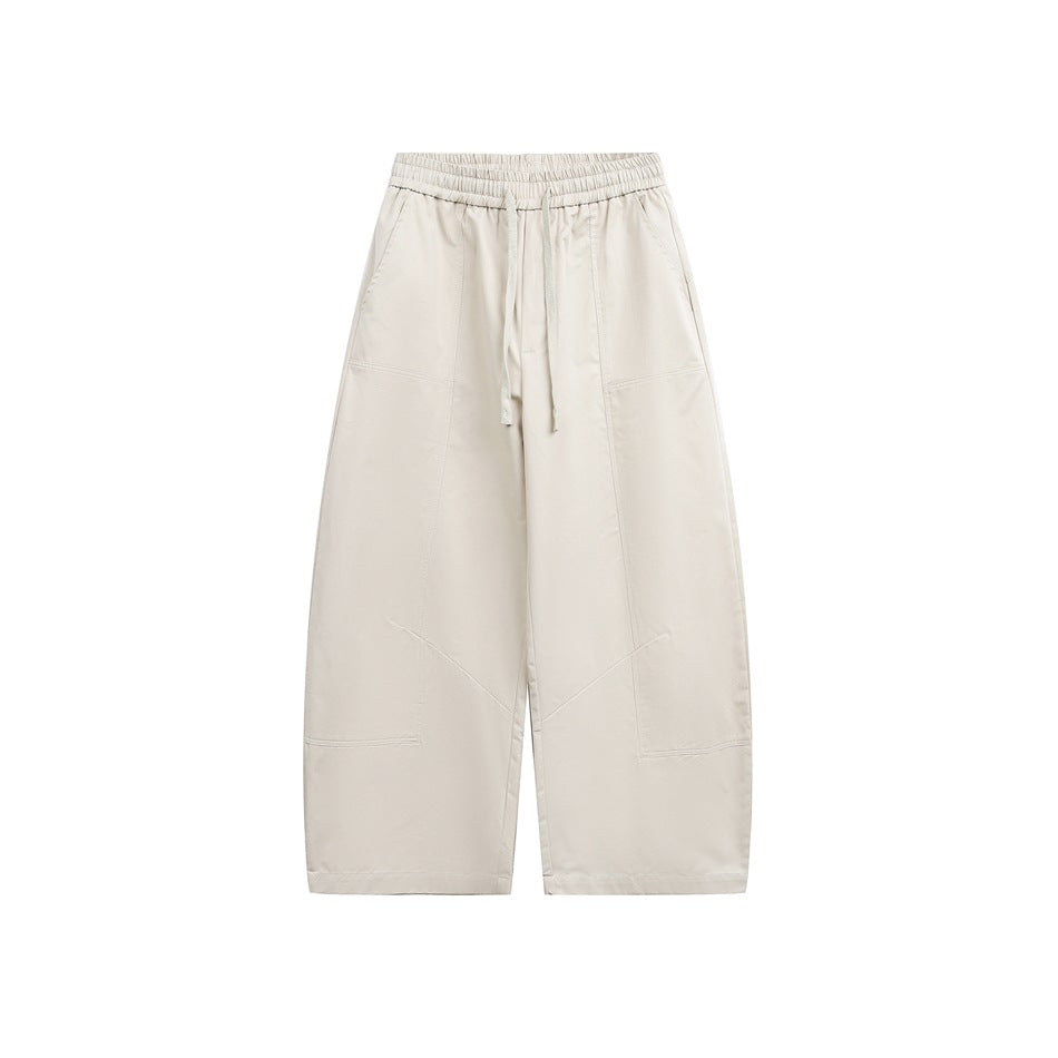 Beige wide-leg drawstring pants with elastic waist, side pockets and paneled seams, front flat view