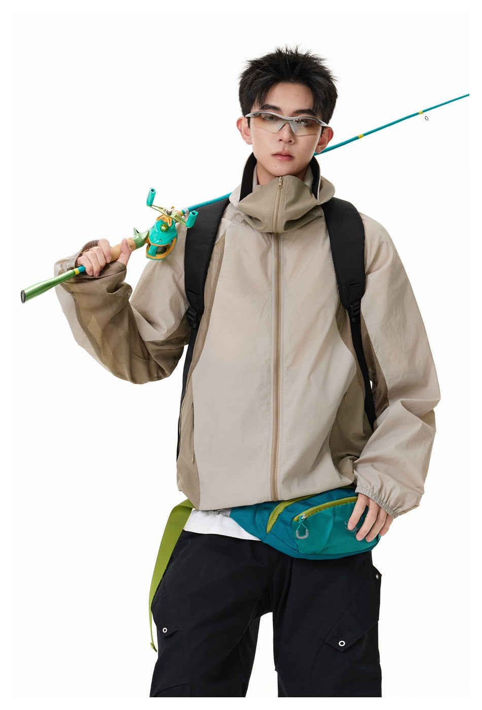 Model wearing a light beige hooded zip jacket with darker mesh side panels, shown from the front.